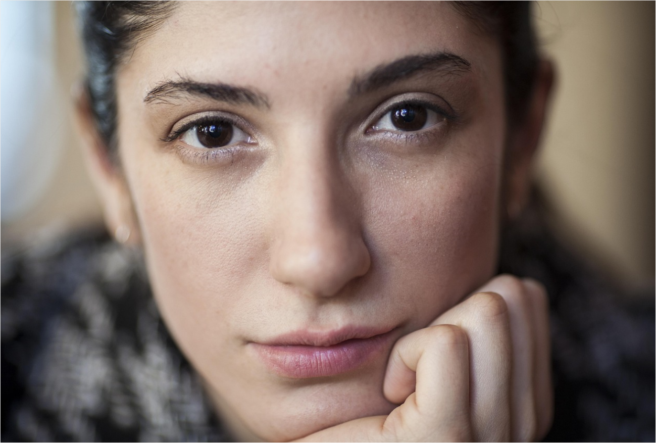 woman looking at camera with hand on chin